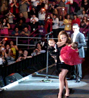 Lopez exits the stage with her twins while Marc looks on...notice the cameras!
